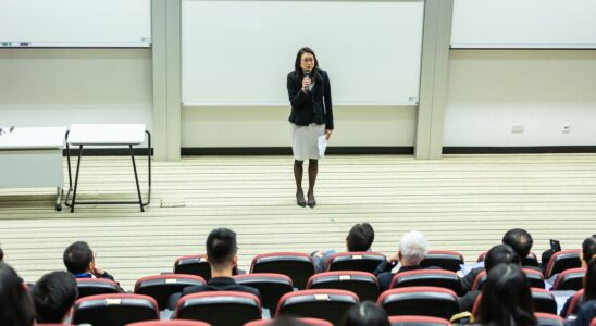 Kvinde holder tale foran klasse