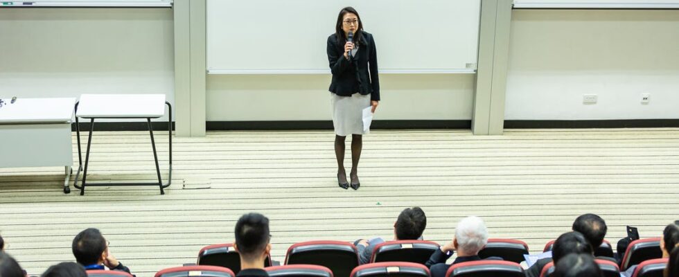 Kvinde holder tale foran klasse